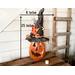A handmade Halloween pumpkin gourd. It is 23 x  8 inches. The pumpkin is wearing a custom black witch hat made from upcycled burlap
